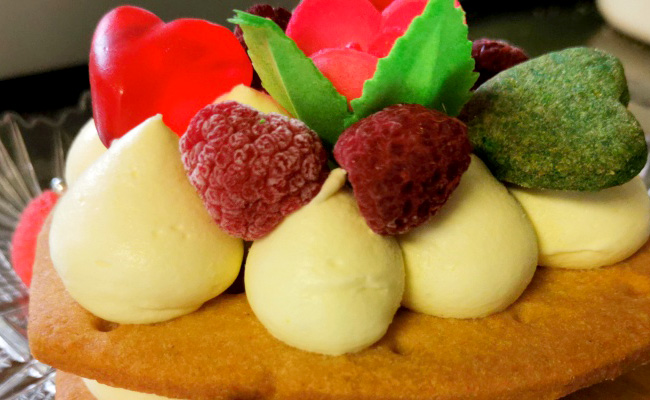 Creme tart a forma di cuore, base biscotto e crema chantilly, con decori a tema