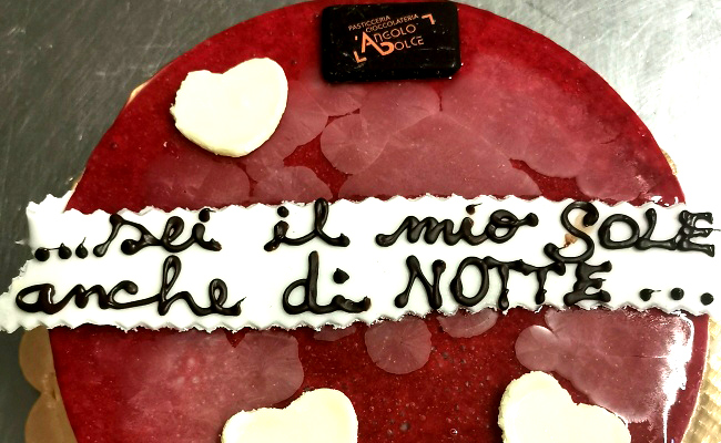 Torta cheescake ai lamponi con scritta tratta da canzoni