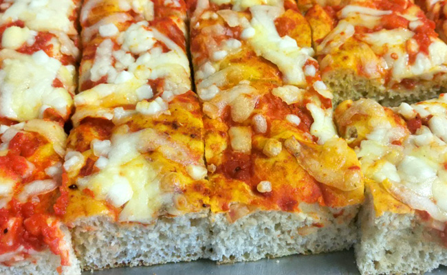 Teglia di pizza margherita tagliata