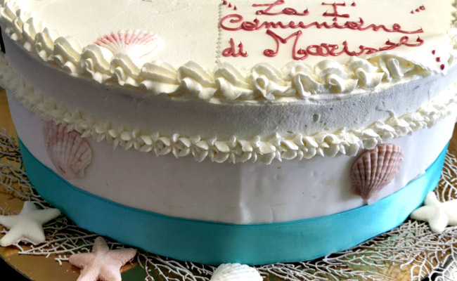 Torta per Comunione, alta, spatolata liscia, con panna e pasta di zucchero, tema marino.