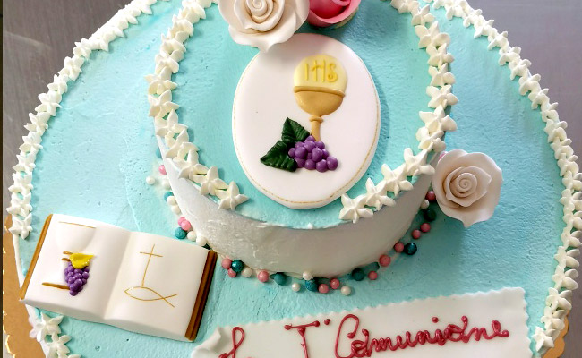 Torta a piani, spatolata con panna bianca e colorata.