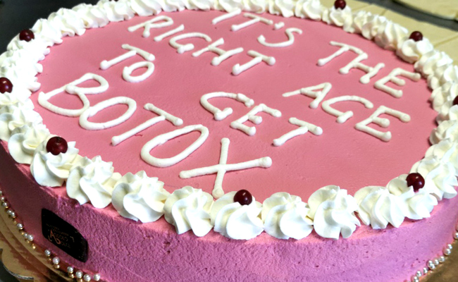 Torta farcita a doppio strato, decorata con panna colorata, scritta Ugly e perline argento
