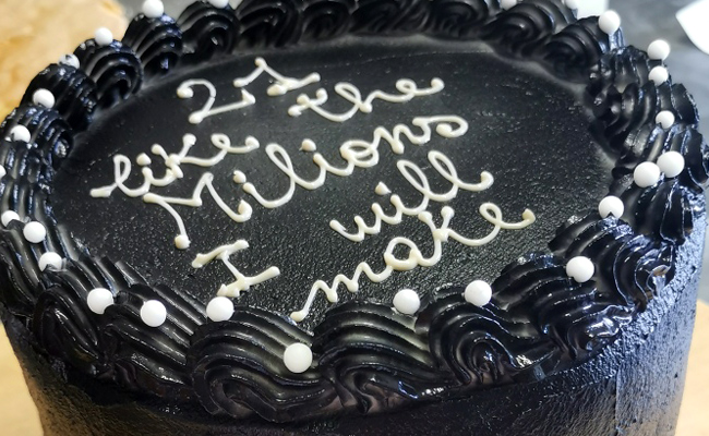 Torta ugly cake nera con scritta e decori bianchi a contrasto.