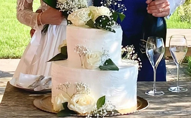 Torta da matrimonio VEGANA farcita con crema Chantilly e crema al cioccolato, coperta con panna e decorata con fiori freschi. Base pan di Spagna.