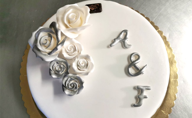 Torta di fidanzamento in bianco e argento, ricoperta in pasta di zucchero e farcita con crema al cioccolato e crema Chantilly