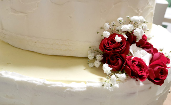 Torta da matrimonio, a 3 piani, decorata con fiori freschi farcita con nocciole, scaglie di cioccolato e chantilly